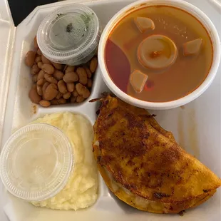 a tray of food including a sandwich, mashed potatoes, and a bowl of soup
