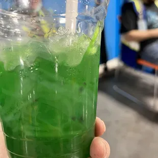 a person holding a green drink