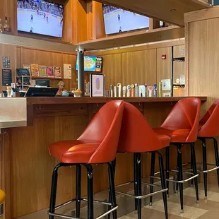 a row of red bar stools