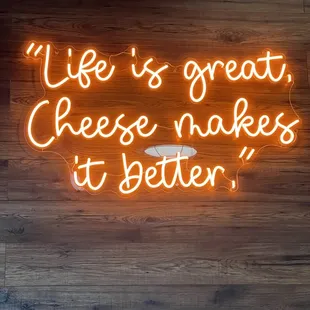 a neon sign that says life is great cheese makes it better