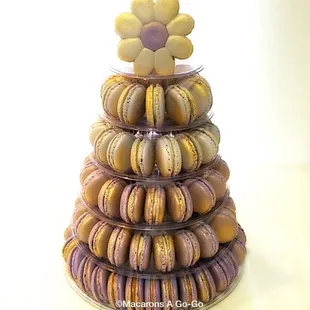 Ombré macaron tower in shades of purple with a splash of gold and a flower as a topper