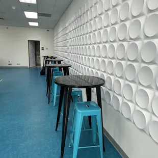 a row of stools in front of a wall