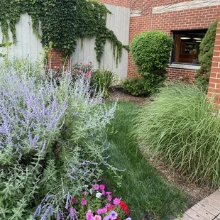 a flower garden in front of a brick building