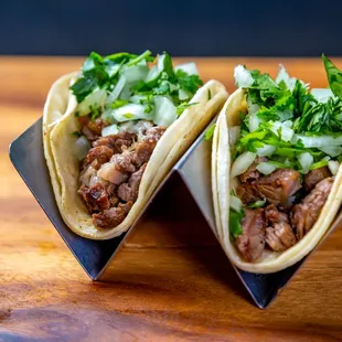 two tacos on a wooden table