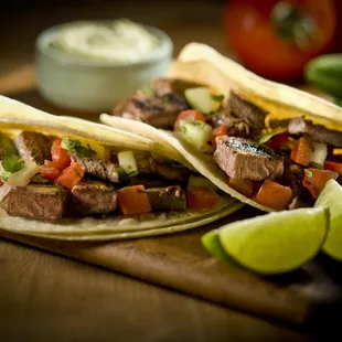 two steak tacos on a cutting board