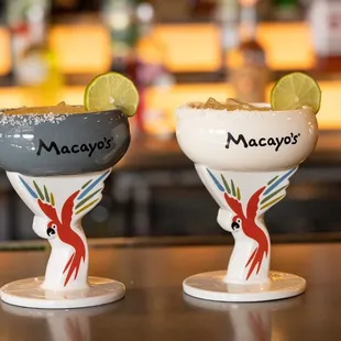 two margarita glasses on a bar