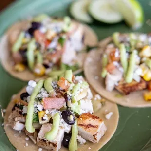 a green plate with three tacoss on it