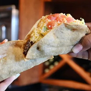 a hand holding a burrito