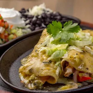 a plate of enchiladas and a bowl of salsa