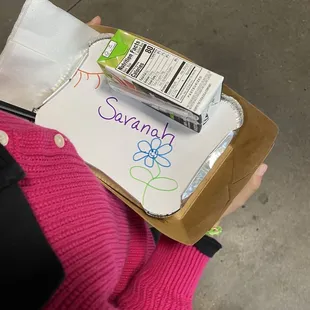 a person holding a box of cereal