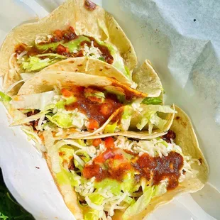 three tacos on a paper plate