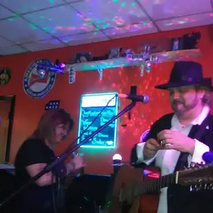 a man in a top hat playing a guitar
