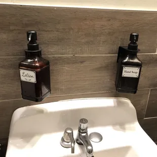  sink with two bottles on the wall