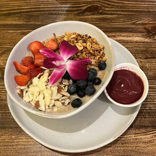 Oatmeal with granola, fresh berries and berry sauce.