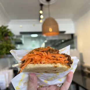 a hand holding a sandwich