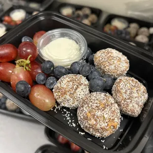 Mango energy bites with dates, coconut, flax seeds, and lime zest. Served with a side of Greek yogurt and mixed fruit.