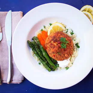 Salmon quinoa cakes with grilled asparagus and carrots on a bed of orzo.