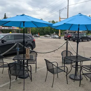 tables and chairs with blue umbrellas