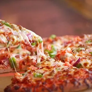 a person taking a slice of pizza