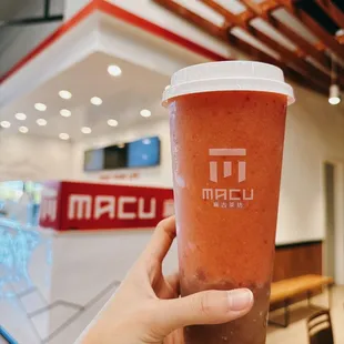 a hand holding a cup of iced coffee