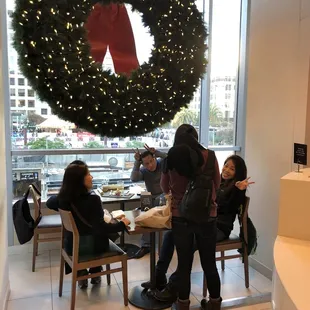 people sitting at a table with a wreath on the wall