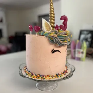 a cake with a unicorn face on top