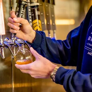 a man filling a beer from a tap