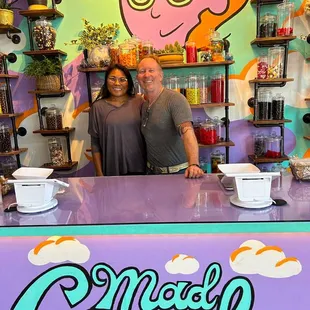 a man and a woman standing behind a counter