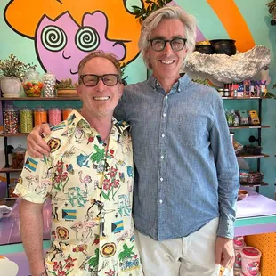 two men standing in front of a candy shop