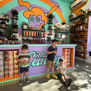 two children standing in front of a candy shop