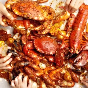 a group of people holding up crabs and corn