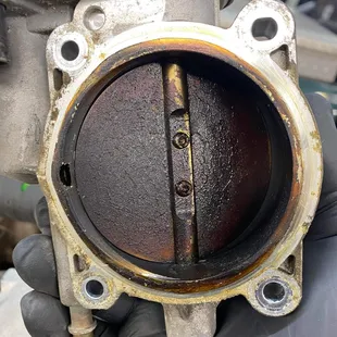 Grime build up on a throttle body. If your car is having trouble accelerating or if your check engine light is on this could be your problem