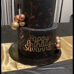a black and gold birthday cake