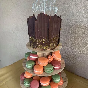 a three tiered cake with a happy birthday sign
