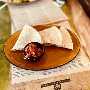 a plate of quesadillas and a bowl of salsa