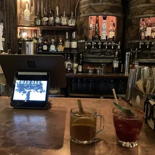 a laptop on a bar with a drink in front of it