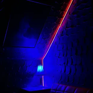 a dark room with a couch and a lamp