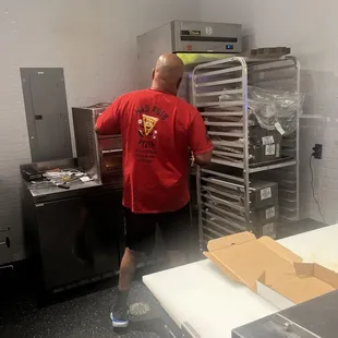 Laron pulling out a hot pizza.