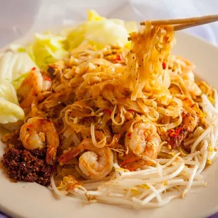  a plate of noodles with shrimp and lettuce