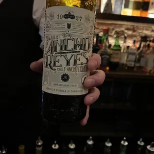 a hand holding a bottle of alcohol