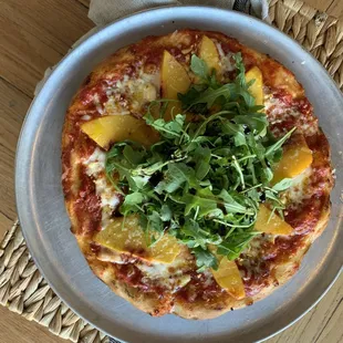 Peach and arugula thin crust pizza.