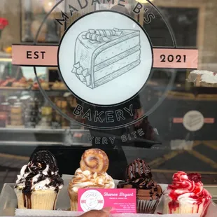 a hand holding a tray of cupcakes