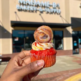 a hand holding a cupcake