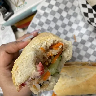 a person holding a sandwich in their hand