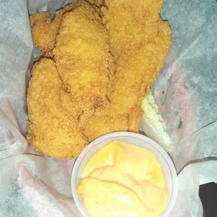 a basket of fried chicken with mustard