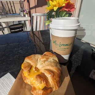 Croissant  breakfast sandwich  with vegan sausage, and a peppermint mocha.