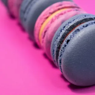 a row of macarons on a pink background
