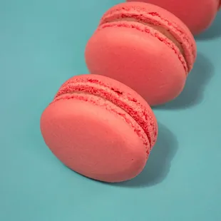 three pink macarons on a blue background