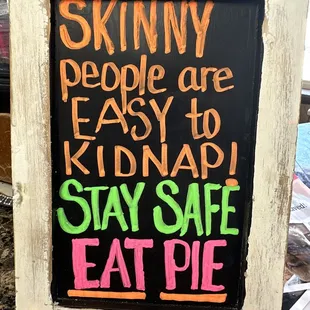 a sign that says skinny people are easy to kidnap stay safe eat pie