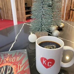 Regular coffee with cute Christmas decorations behind!